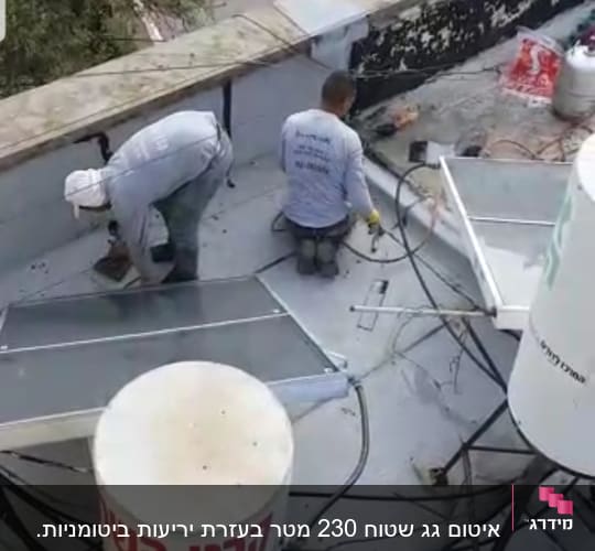 שני עובדים מבצעים איטום על גג עם יריעות ביטומניות.